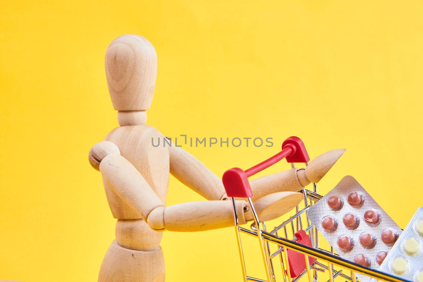 wooden dummy with medicine cart yellow background. High quality photo