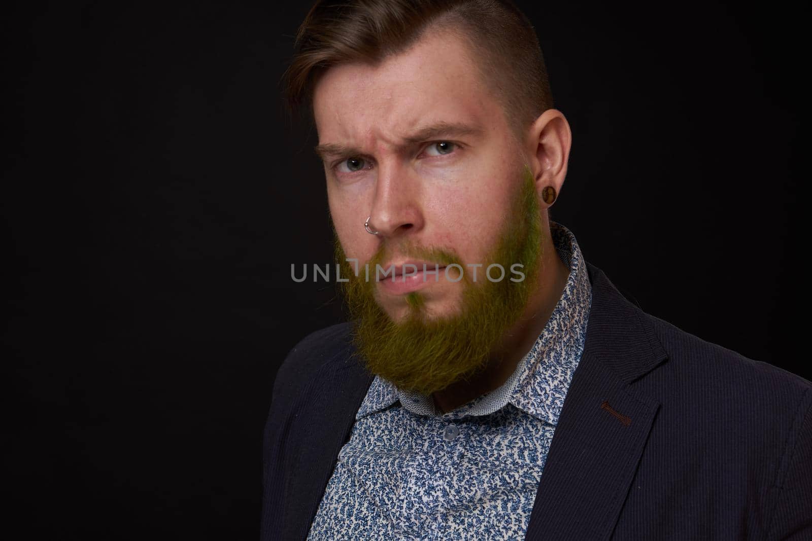 fashionable business man in a jacket with a beard posing. High quality photo