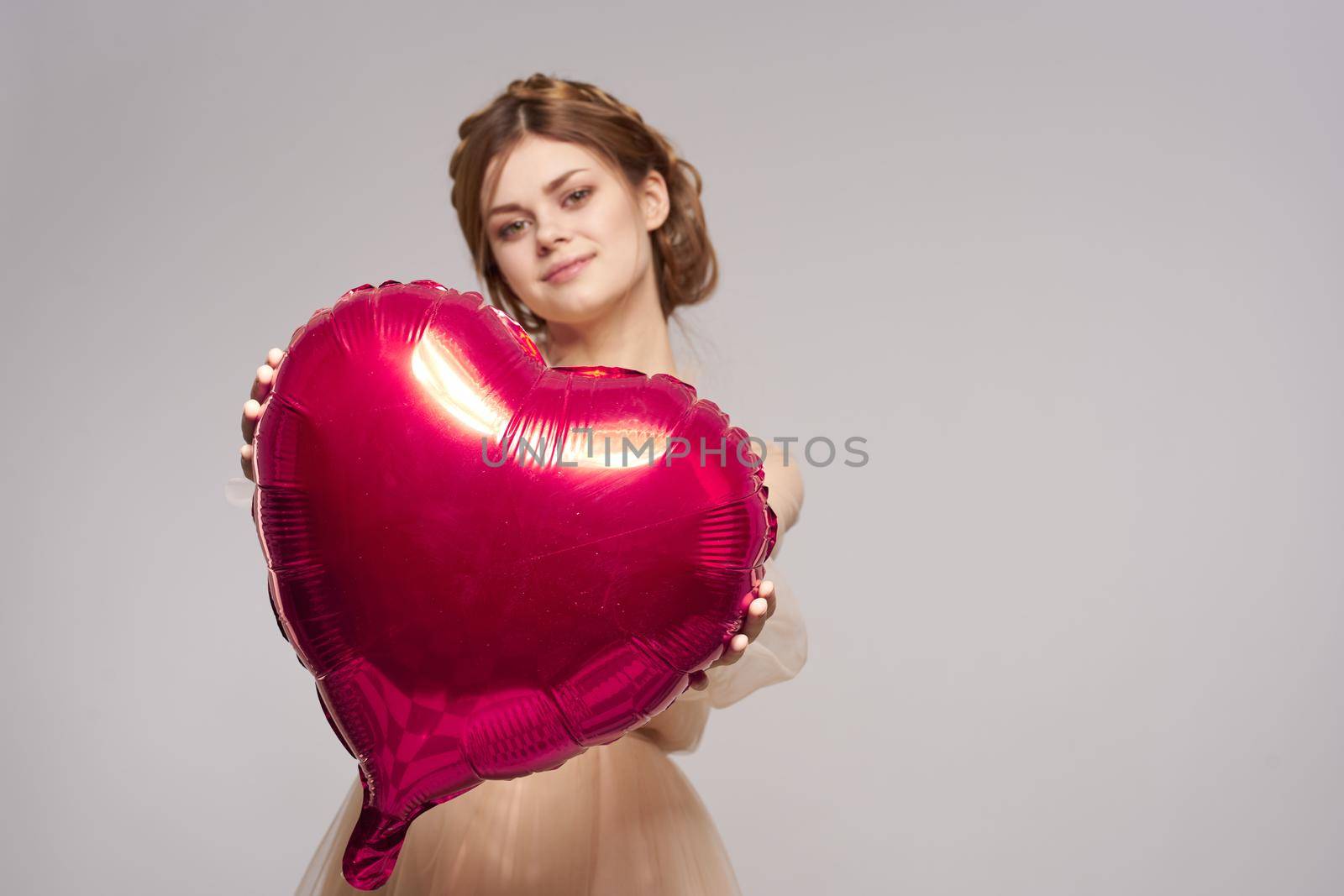 cheerful woman in a dress balloon Valentine's Day model studio. High quality photo