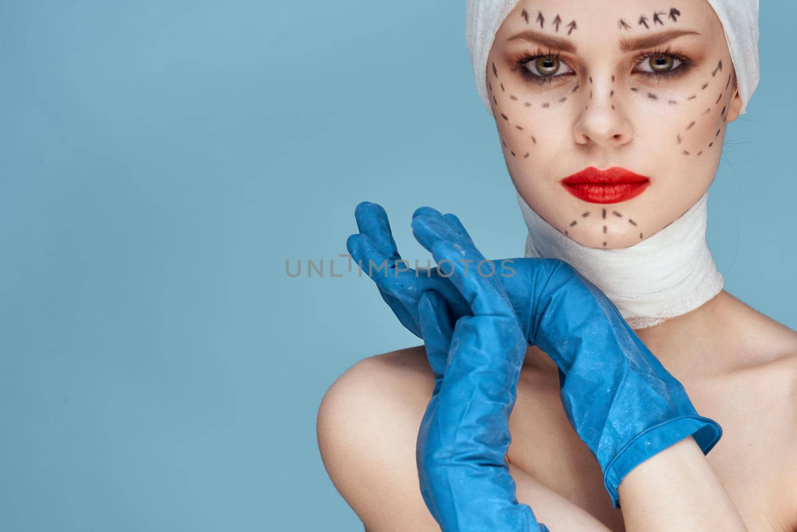 female patient posing in blue gloves red lips surgery facial rejuvenation studio lifestyle. High quality photo