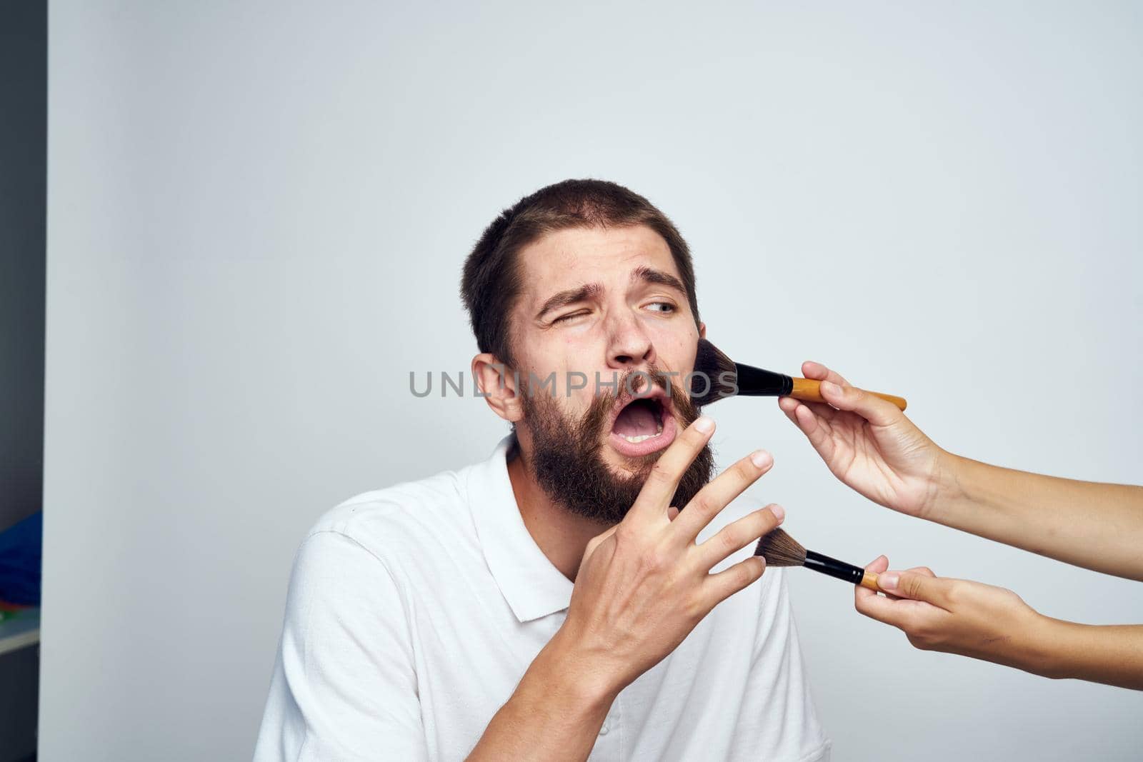 bearded man in white shirt cosmetics makeup. High quality photo