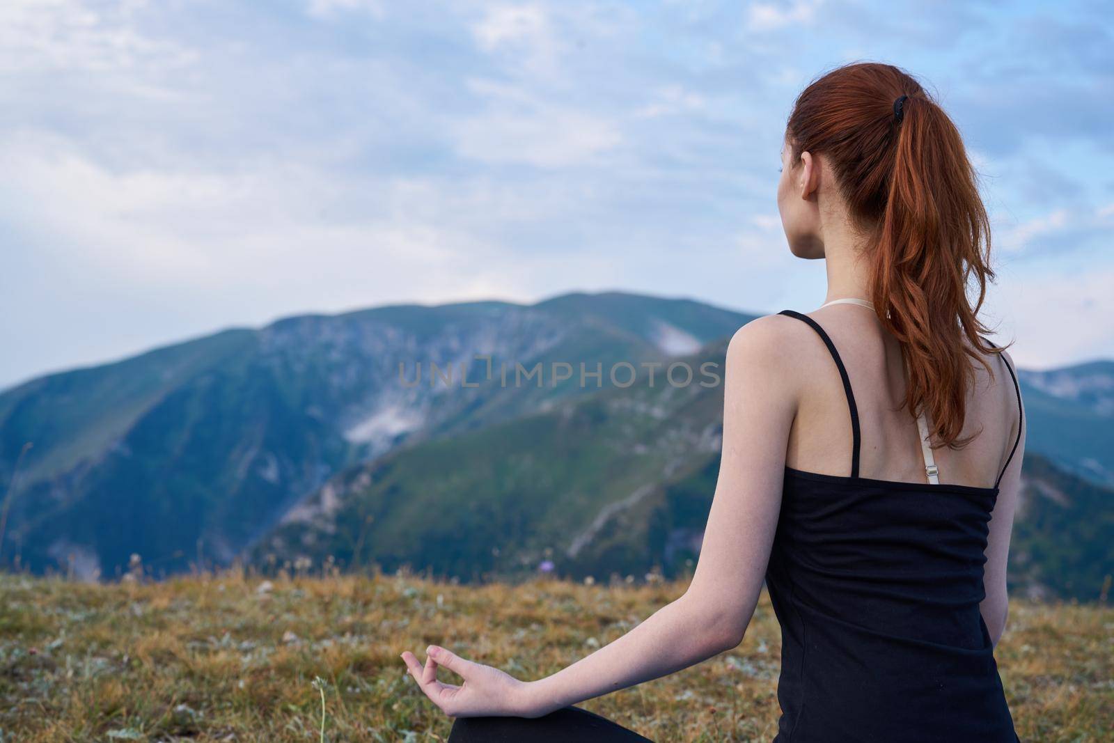 sportive woman workout meditation in the mountains outdoors. High quality photo