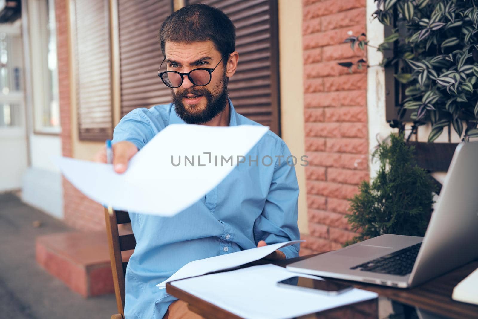 business man in cafe with laptop working outdoors. High quality photo
