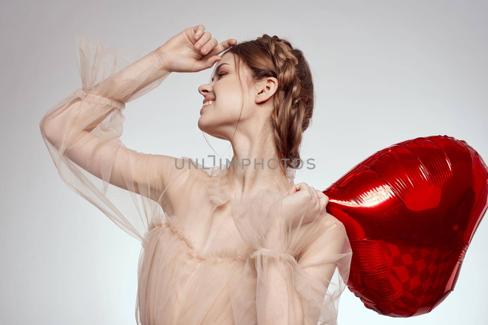 cheerful woman in a dress balloon Valentine's Day model studio. High quality photo