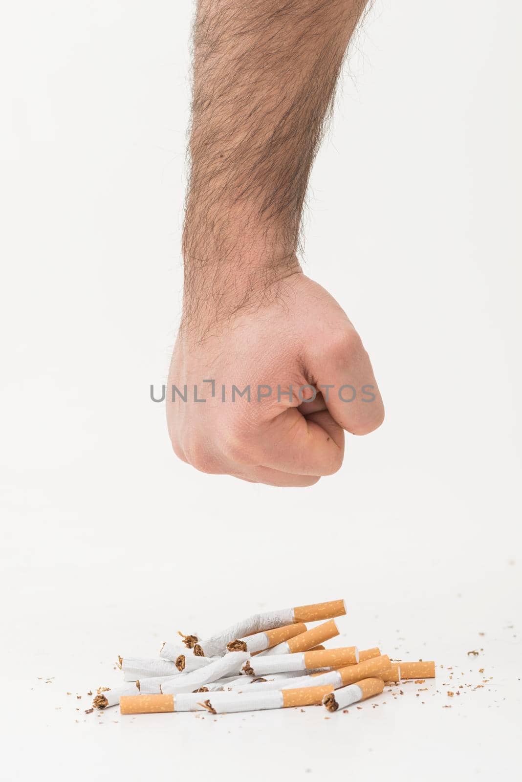 man s hand giving punch broken cigarettes isolated white backdrop. High resolution photo
