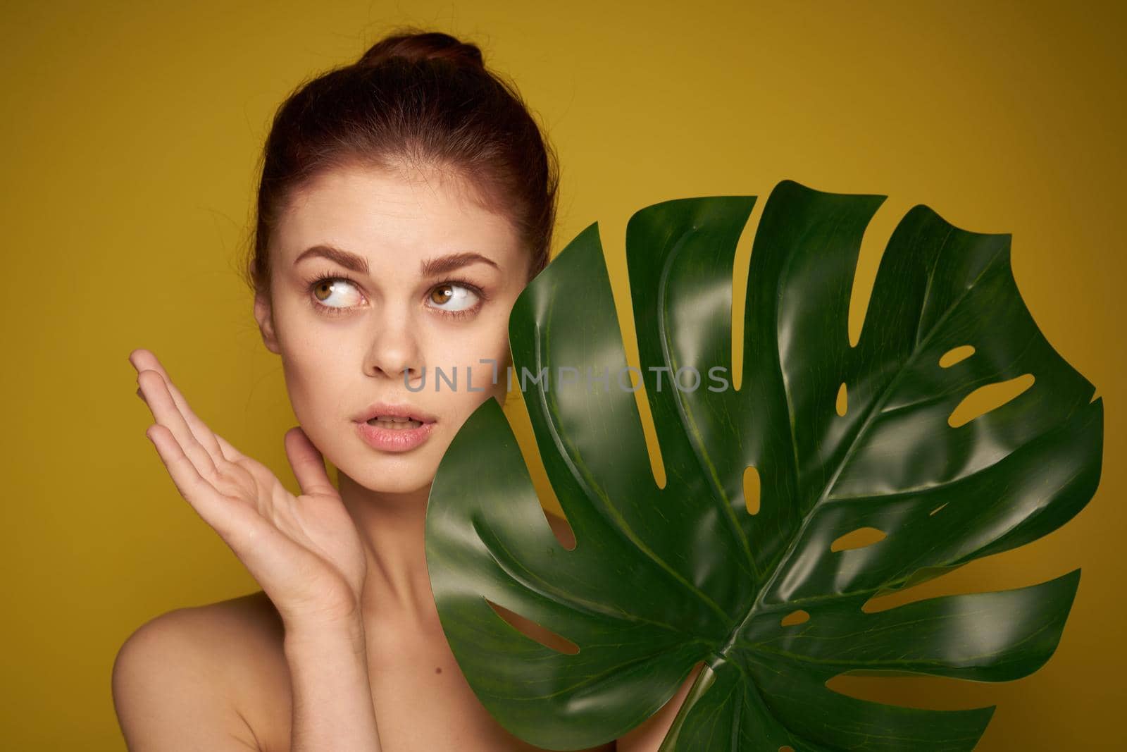 pretty woman palm leaf bare shoulders isolated background. High quality photo