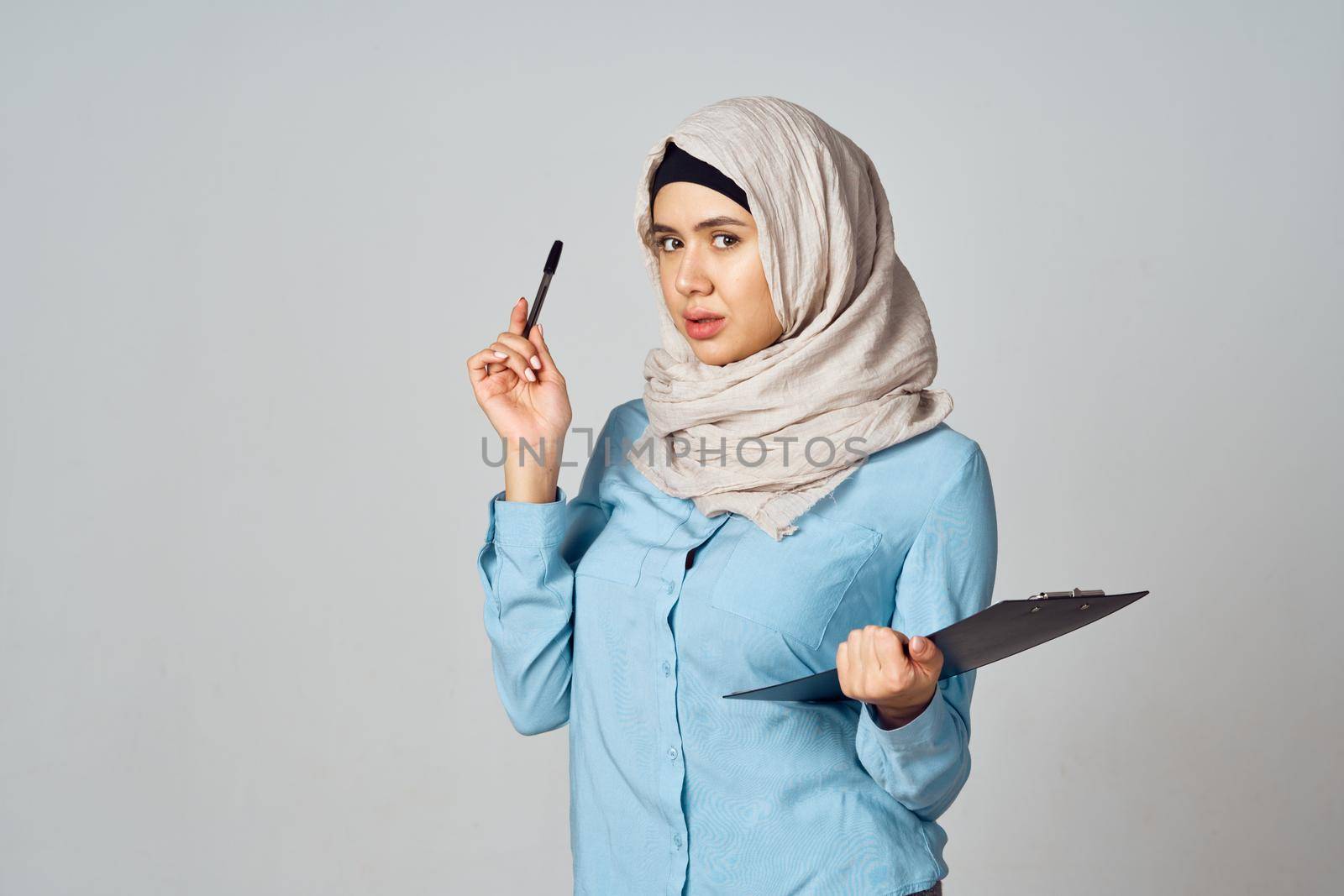 Muslim woman in hijab documents office work by Vichizh