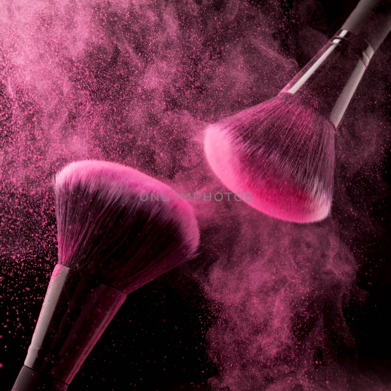 two cosmetic brushes pink powder dark background. High resolution photo