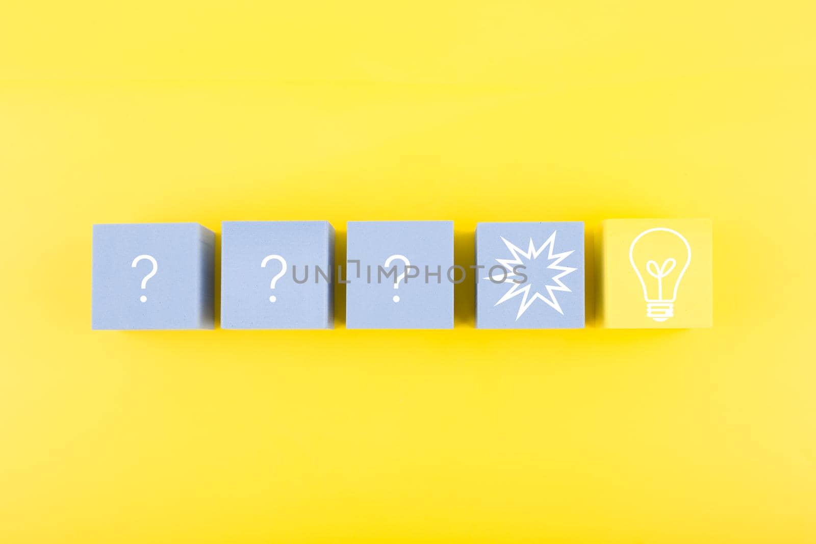 Creativity, brainstorming and fresh ideas concept. Light bulb and question signs drawn on toy cubes on yellow background  by Senorina_Irina