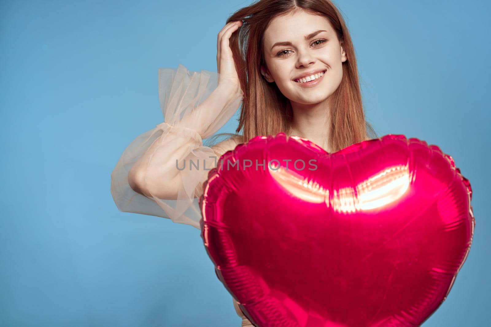 pretty woman red heart in the hands of the balloon blue background. High quality photo