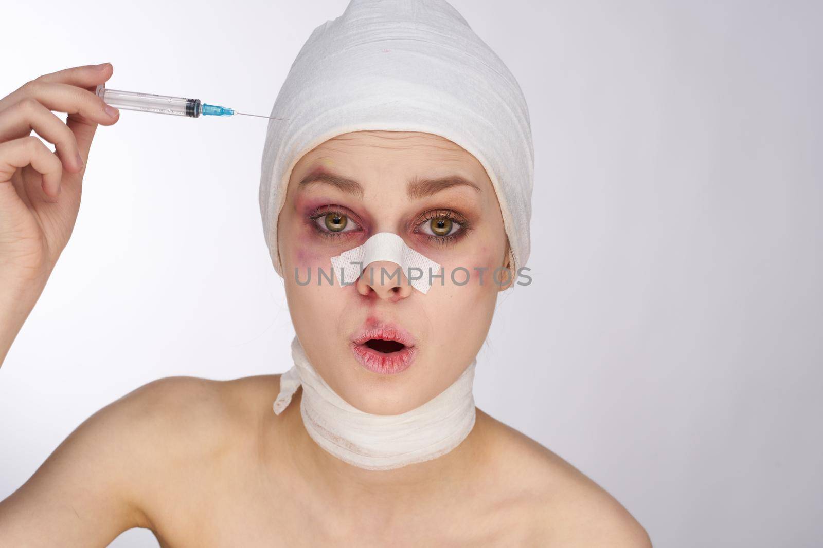 emotional woman bandaged face the syringe sticks out in the head light background by Vichizh