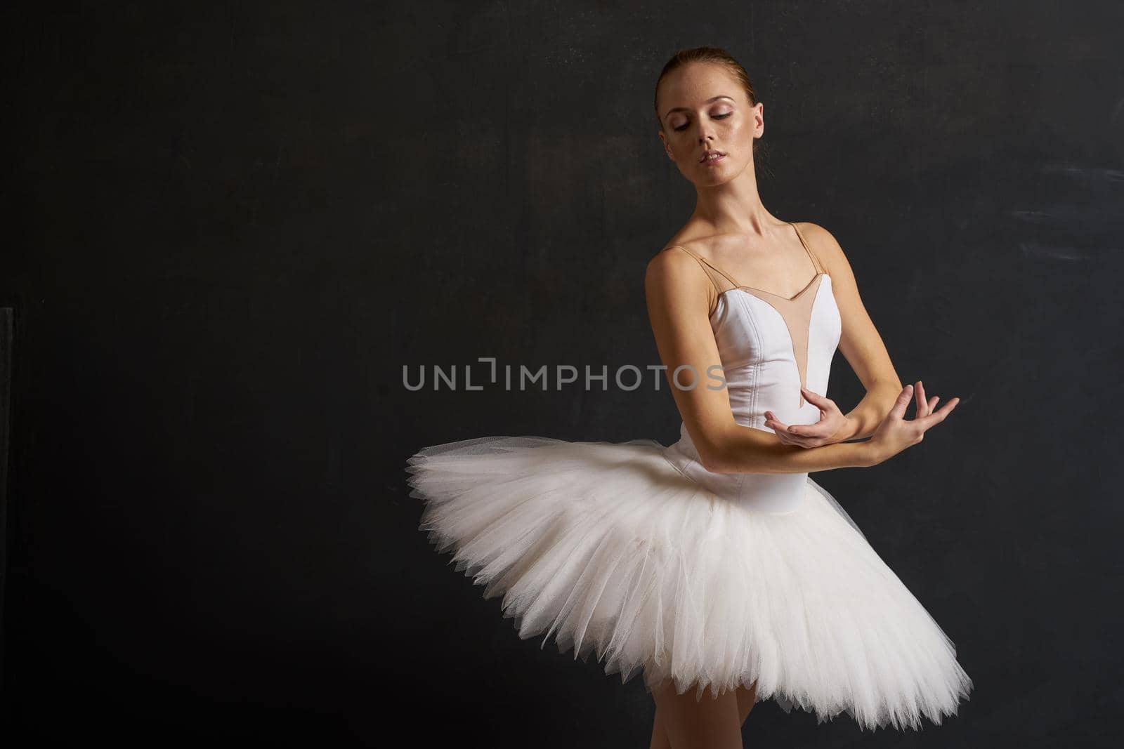 ballerina in a white tutu dance performance silhouette dark background. High quality photo