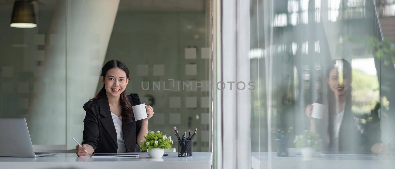 Charming asian businesswoman sitting working on laptop in office. banner aspect
