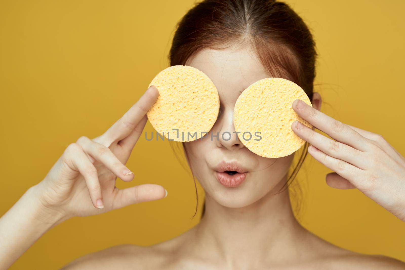 pretty woman with sponges in her hands bare shoulders clean skin hygiene. High quality photo