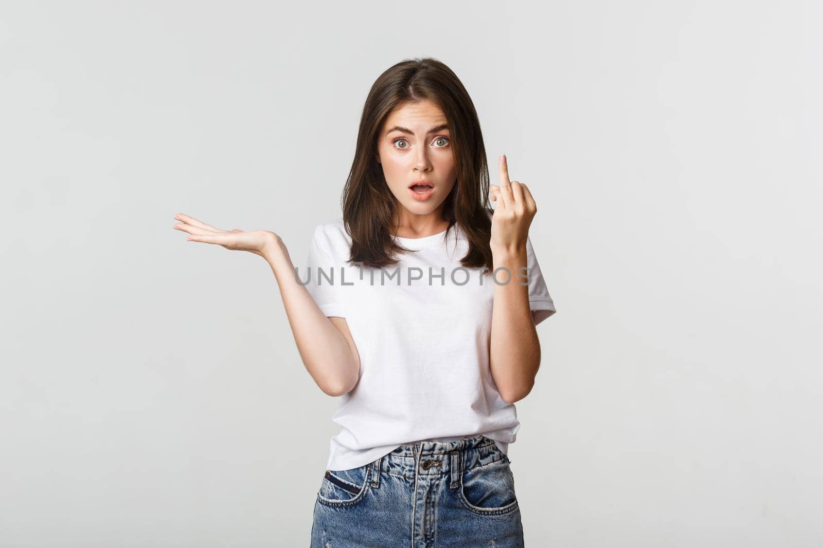 Confused and pissed-off brunette girl arguing about wedding, showing finger without ring.