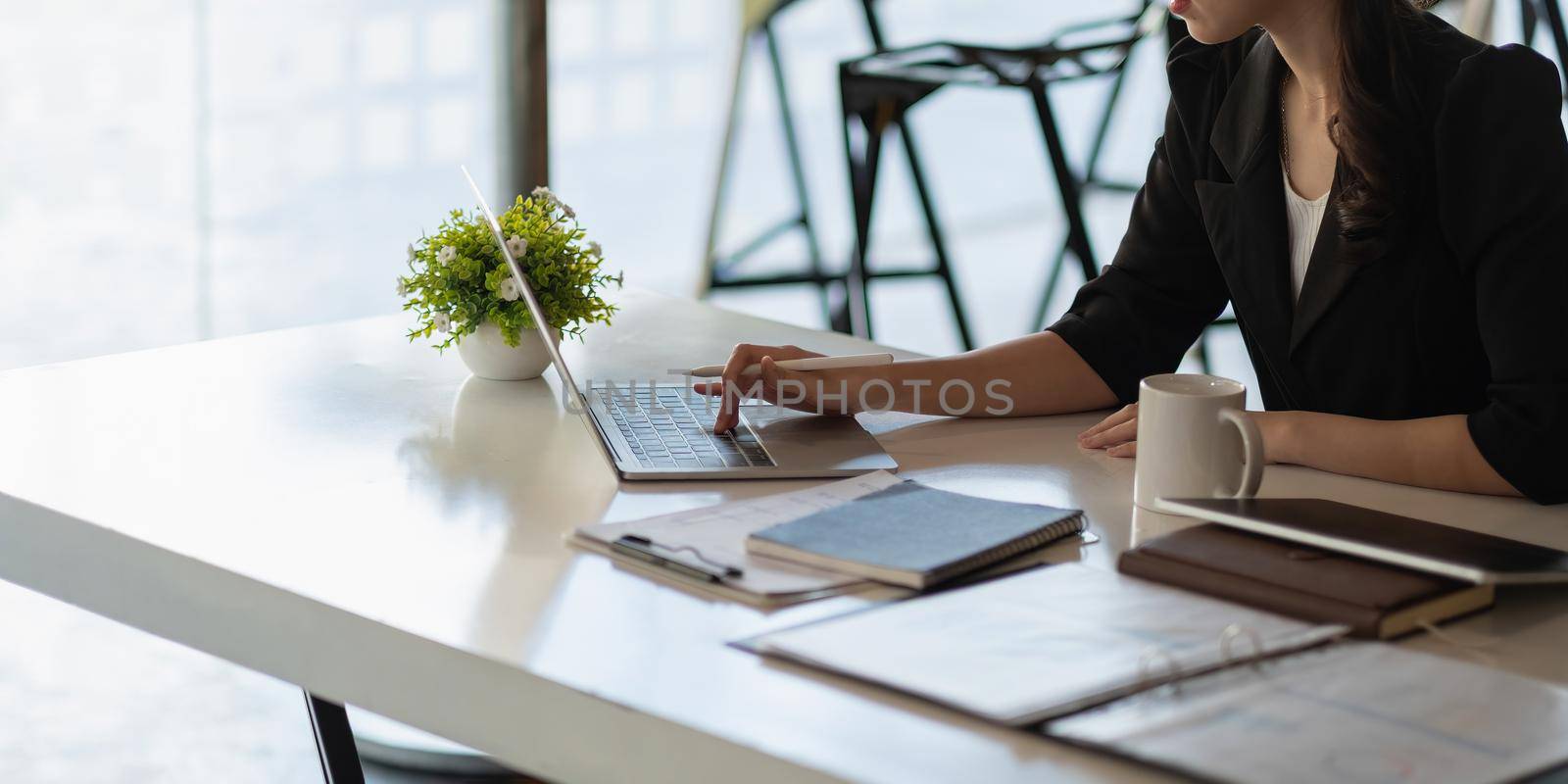 Close up young beautiful asian businesswoman working on laptop in modern office, business finance concept by nateemee