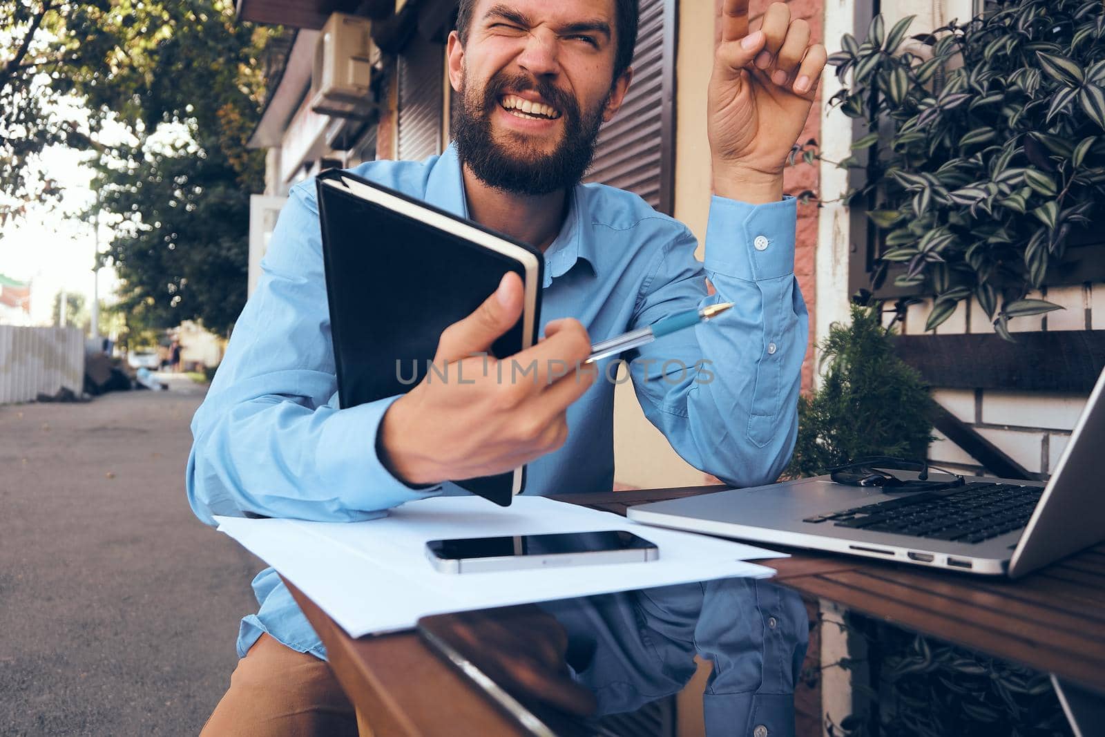 cheerful man with laptop in cafe work technology by Vichizh