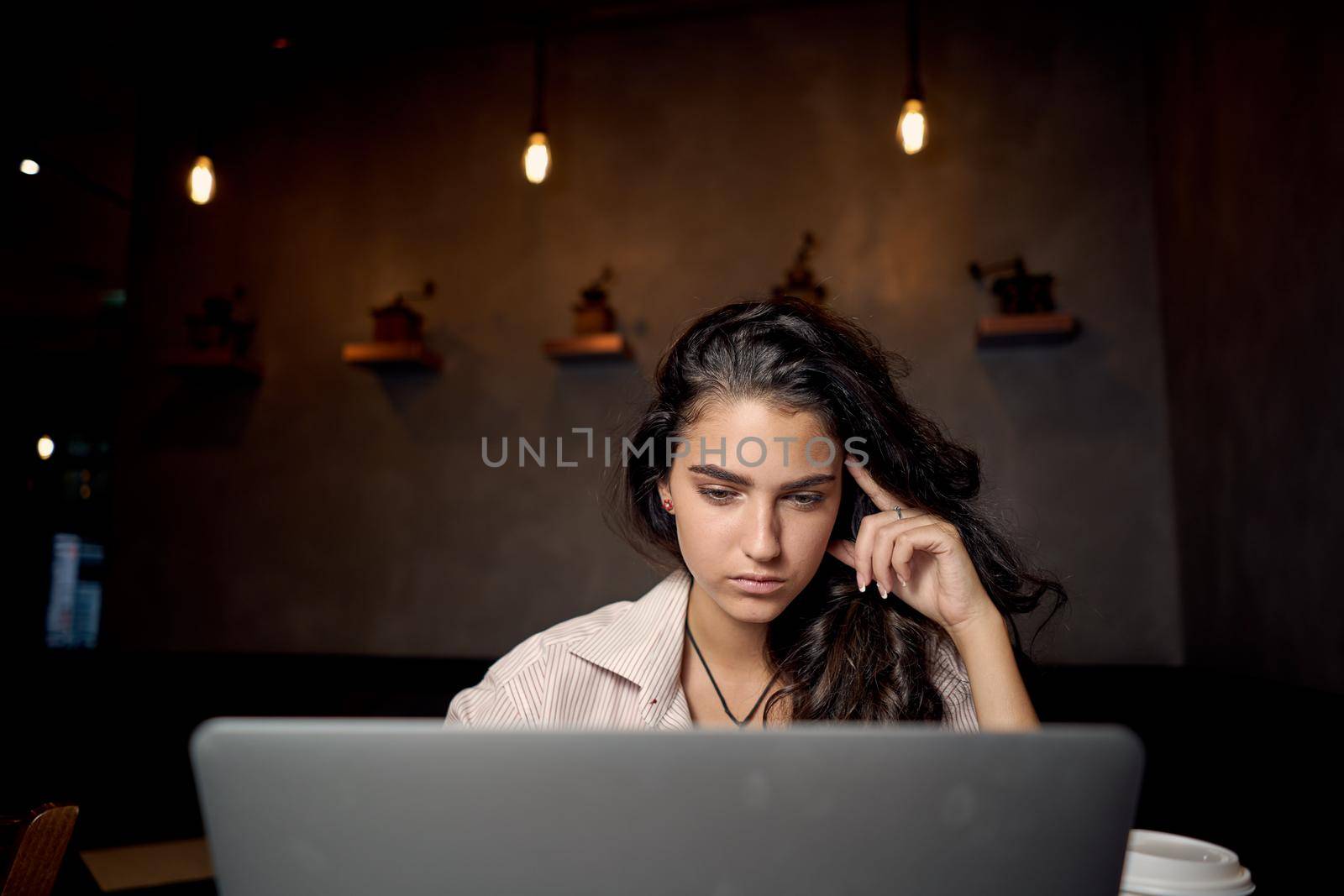 woman sitting in cafe in front of laptop working technology by Vichizh