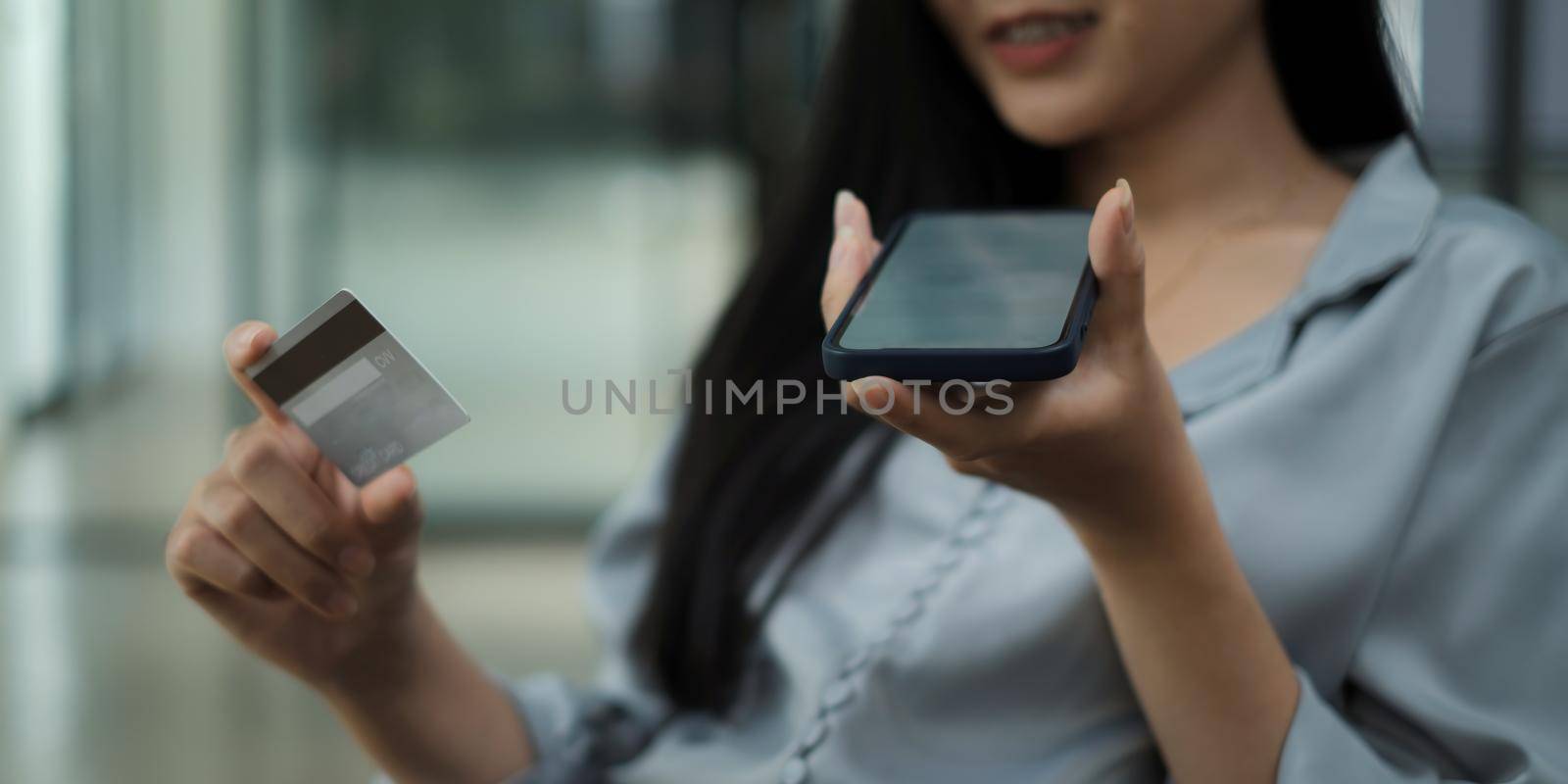 Hands holding smartphone blank screen and credit card. by itchaznong