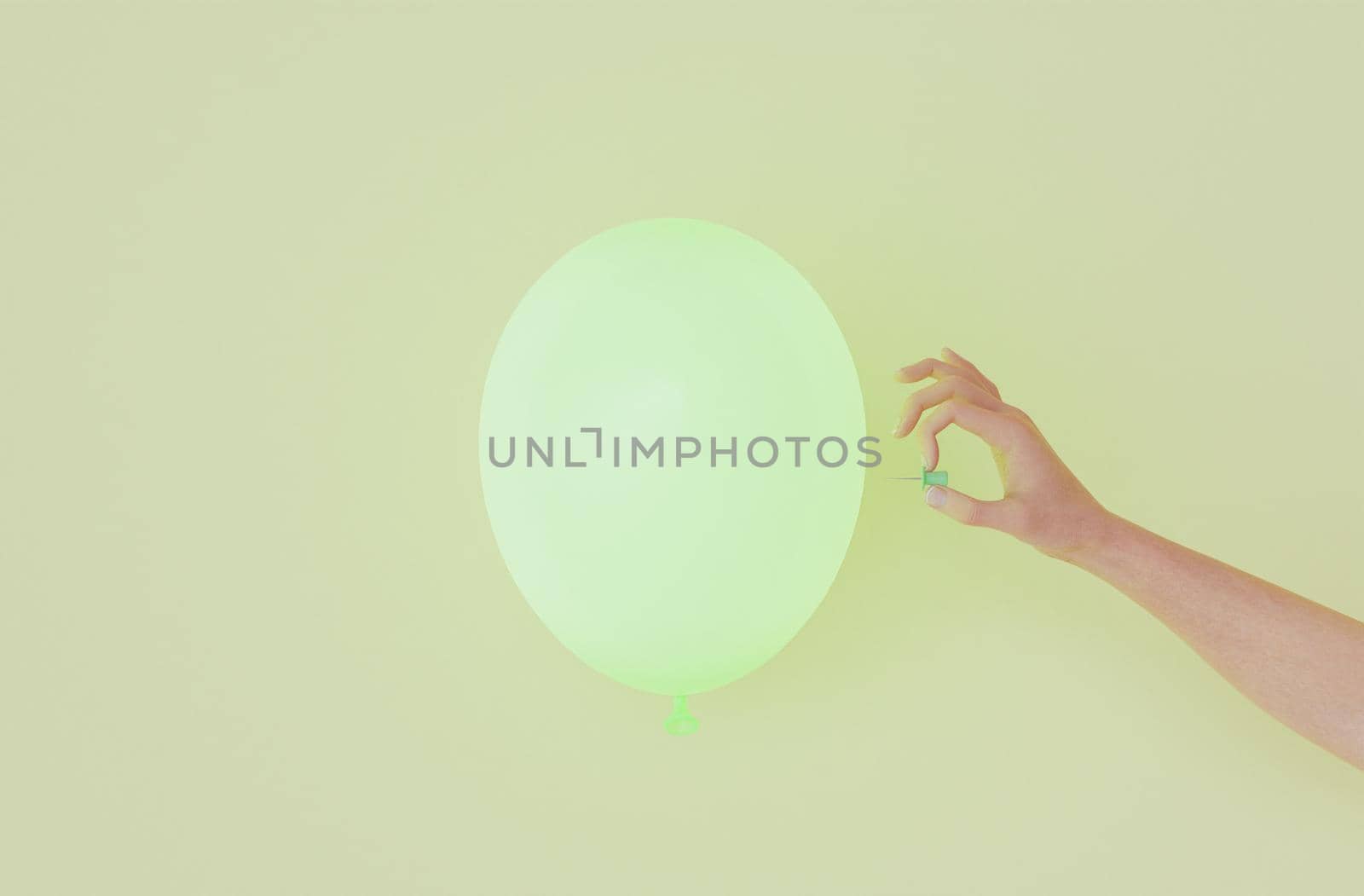 green balloon with a hand going to poke it with a thumbtack. 3d render