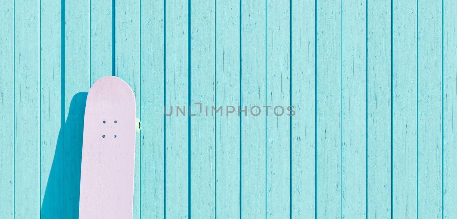 pink skateboard on vintage style blue wooden wall with space for text. 3d render