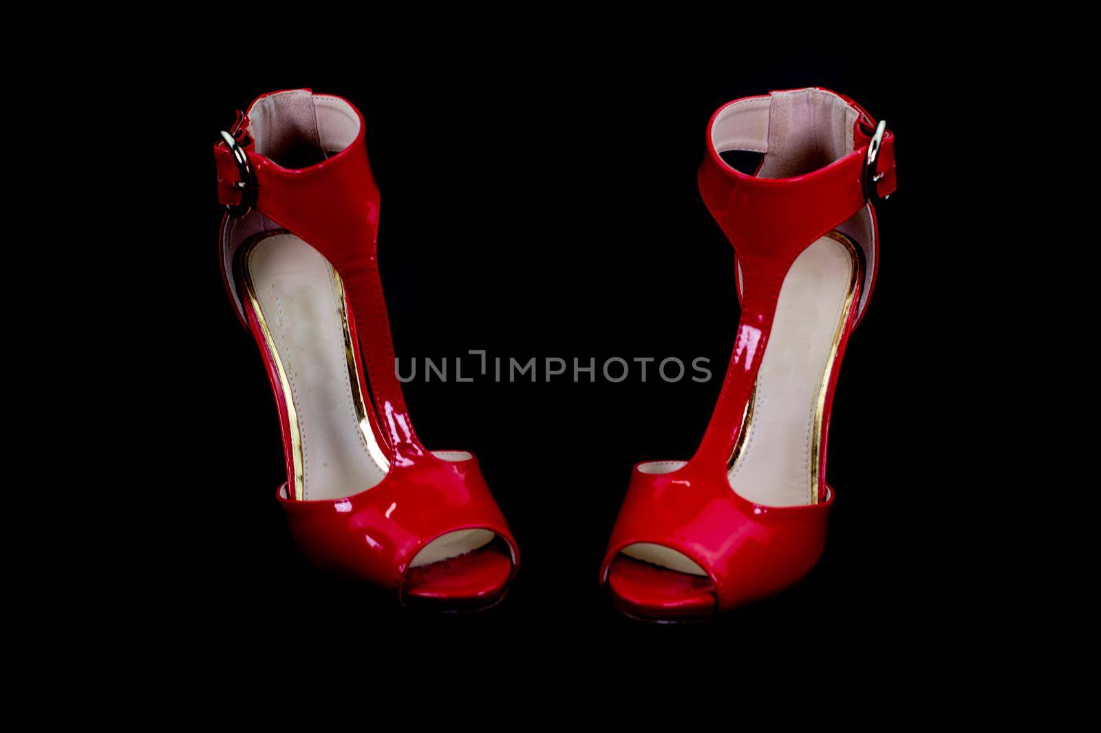 red patent leather sandal for the summer season on a black background