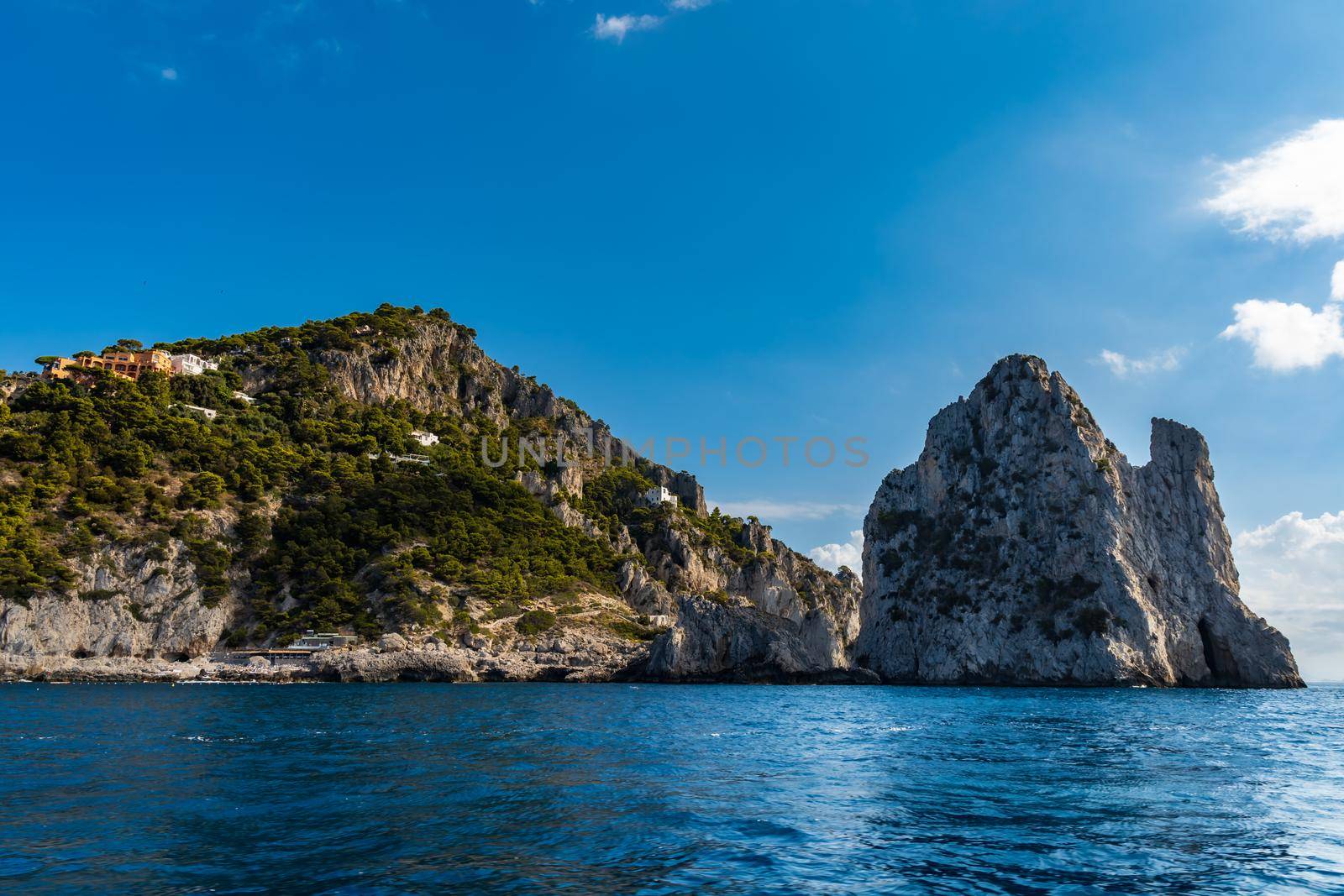 Beautiful panorama of small bay next to Faraglioni di Mezzo and Capri island 