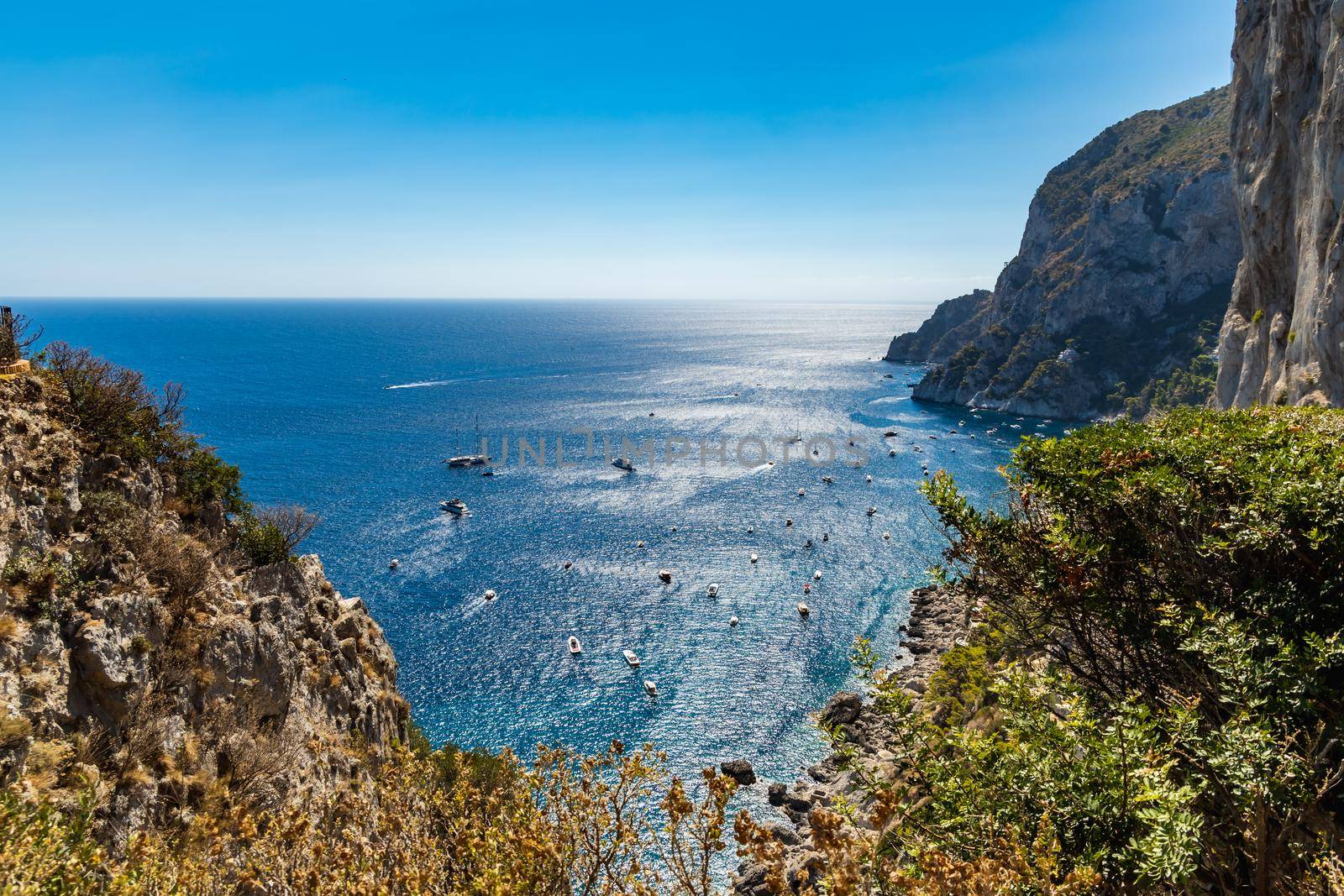 Beautiful panorama of small bay full of small ships and boats next to Capri island 