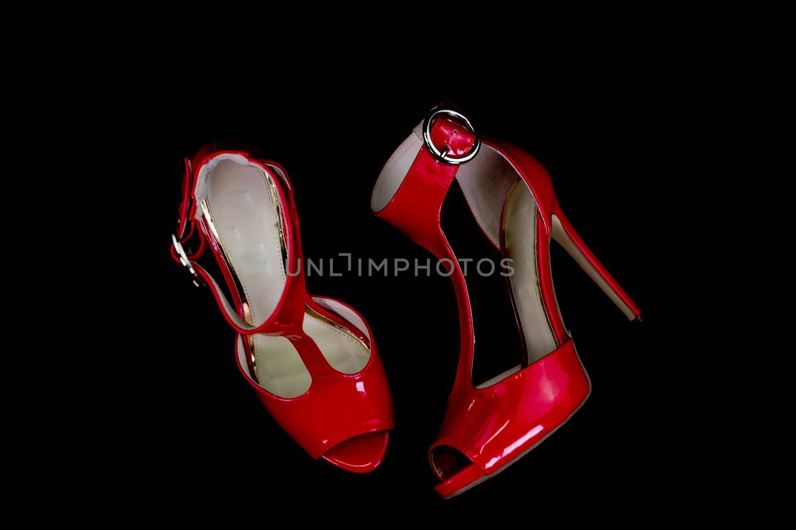 red patent leather sandal for the summer season on a black background