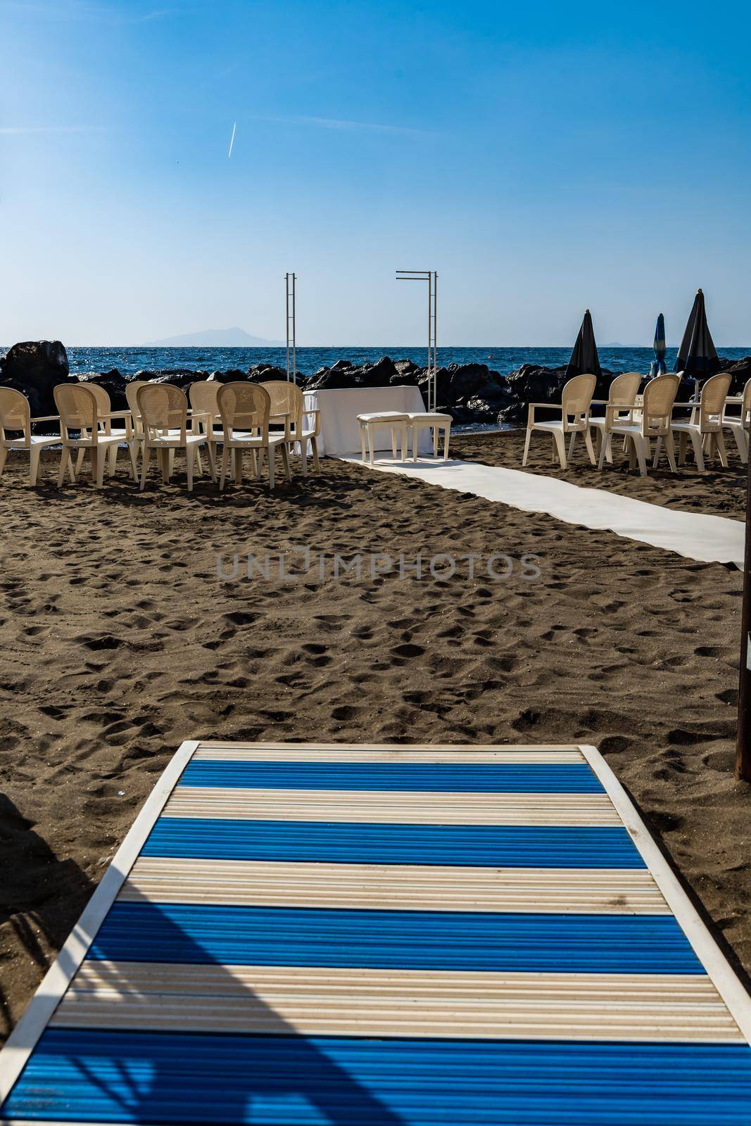 Preparations of wedding party on small beach next to sea and big rocks