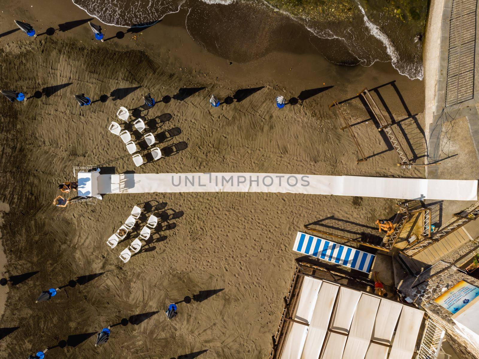 Aerial drone top down view to preparations of wedding on small beach by Wierzchu