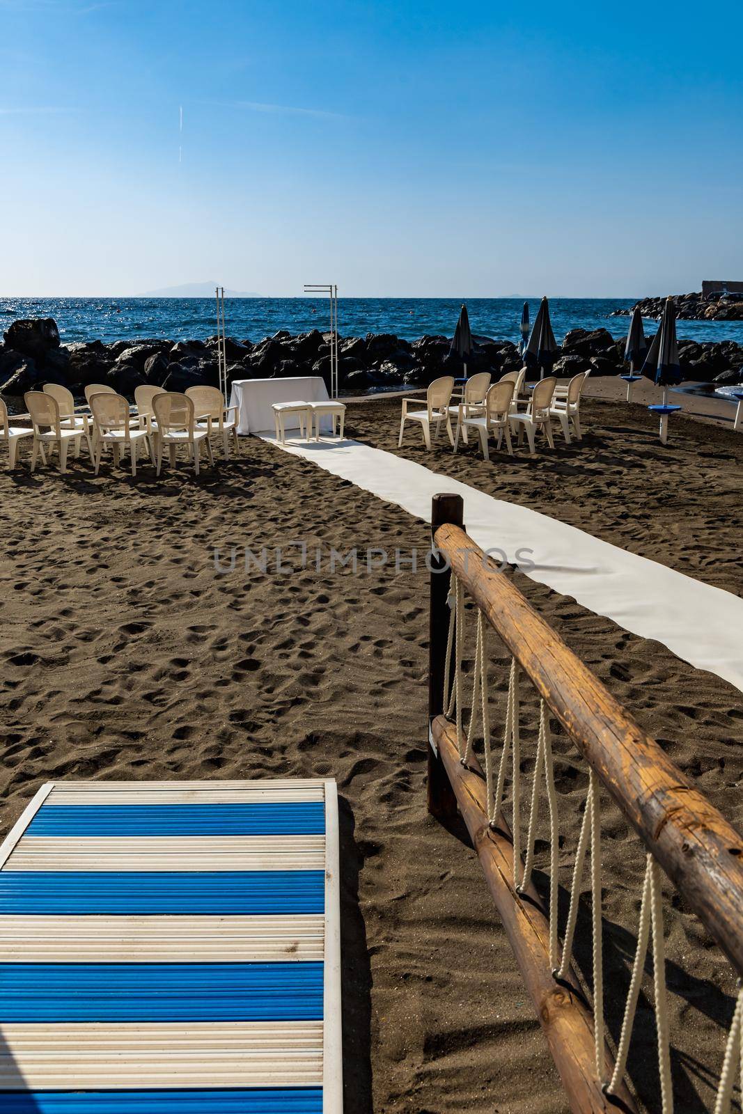 Preparations of wedding party on small beach next to sea and big rocks by Wierzchu