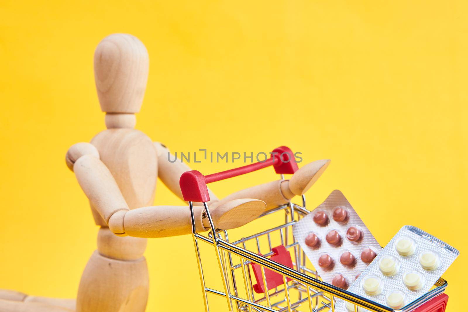 wooden dummy with medicine cart yellow background. High quality photo