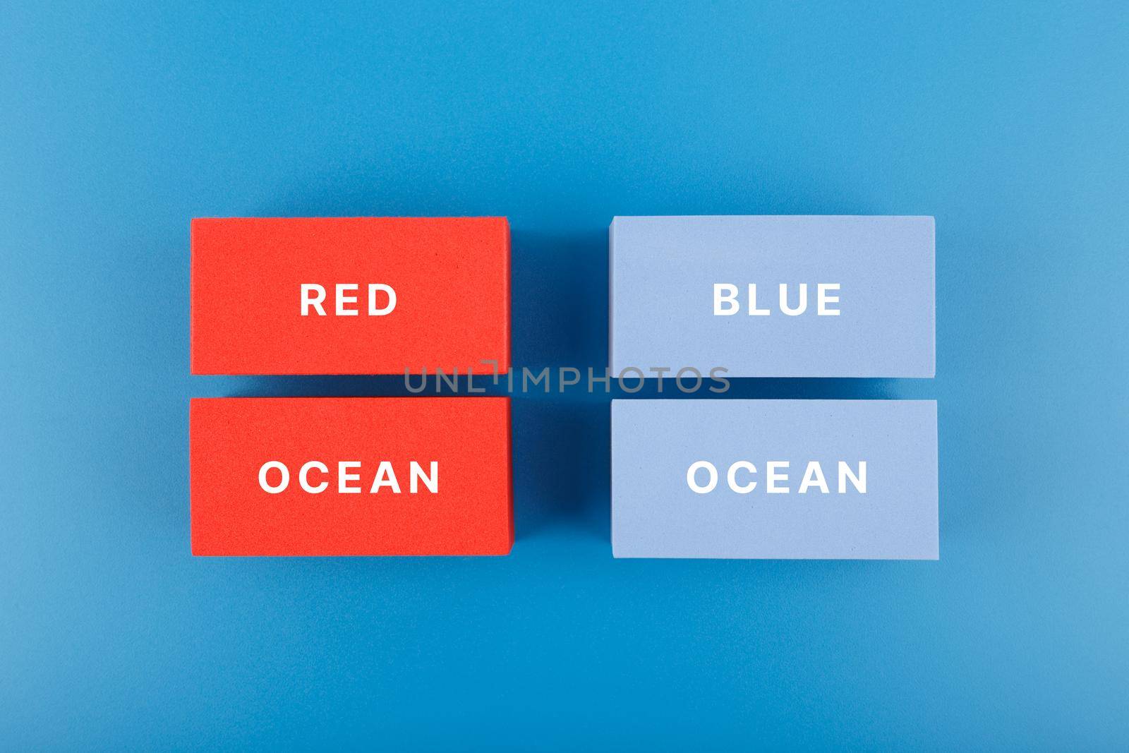 Marketing red ocean and blue ocean business strategy concept. Flat lay, close up, text on blue and red rectangles on blue background. by Senorina_Irina