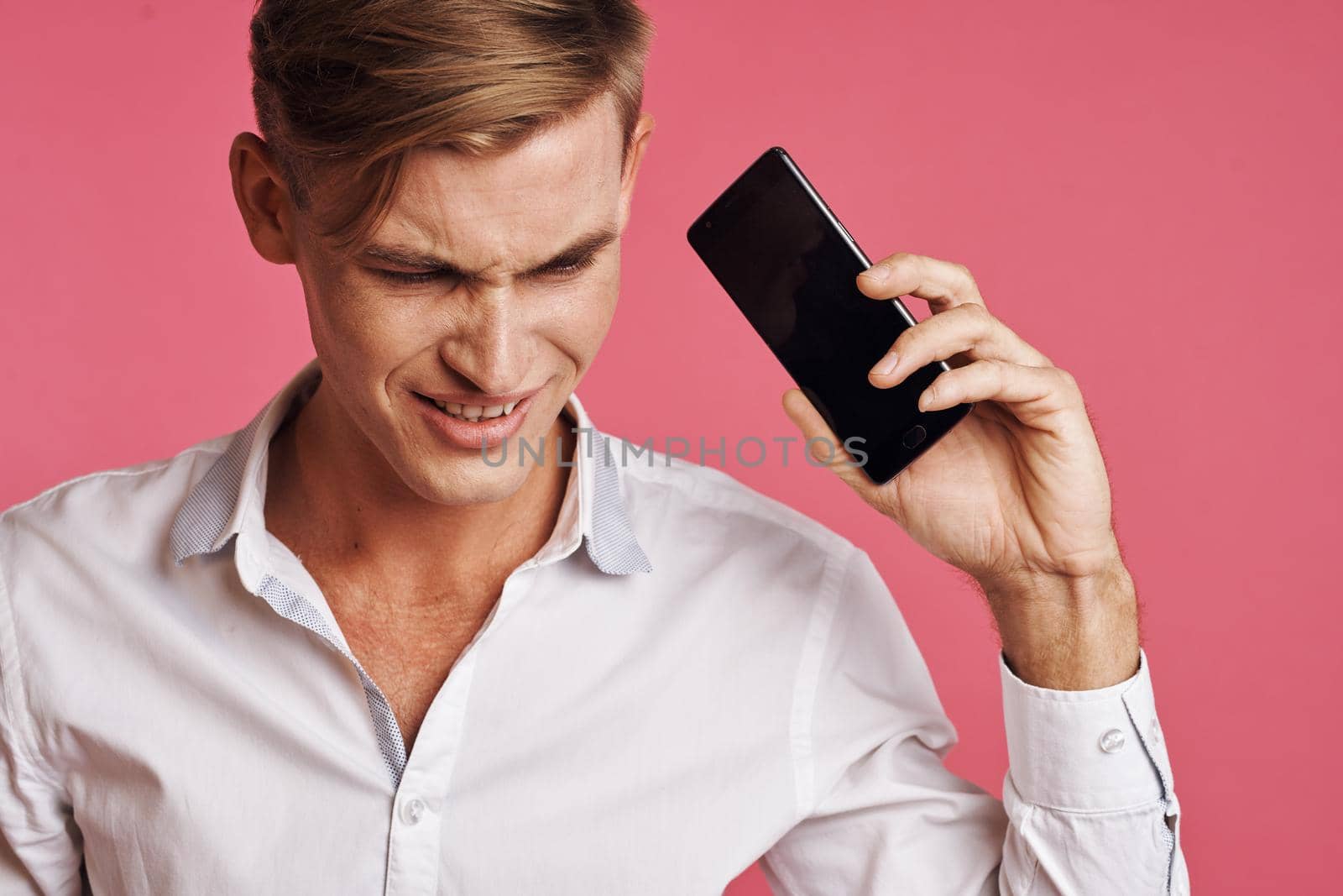 handsome man with a phone in hand fashion posing isolated background. High quality photo