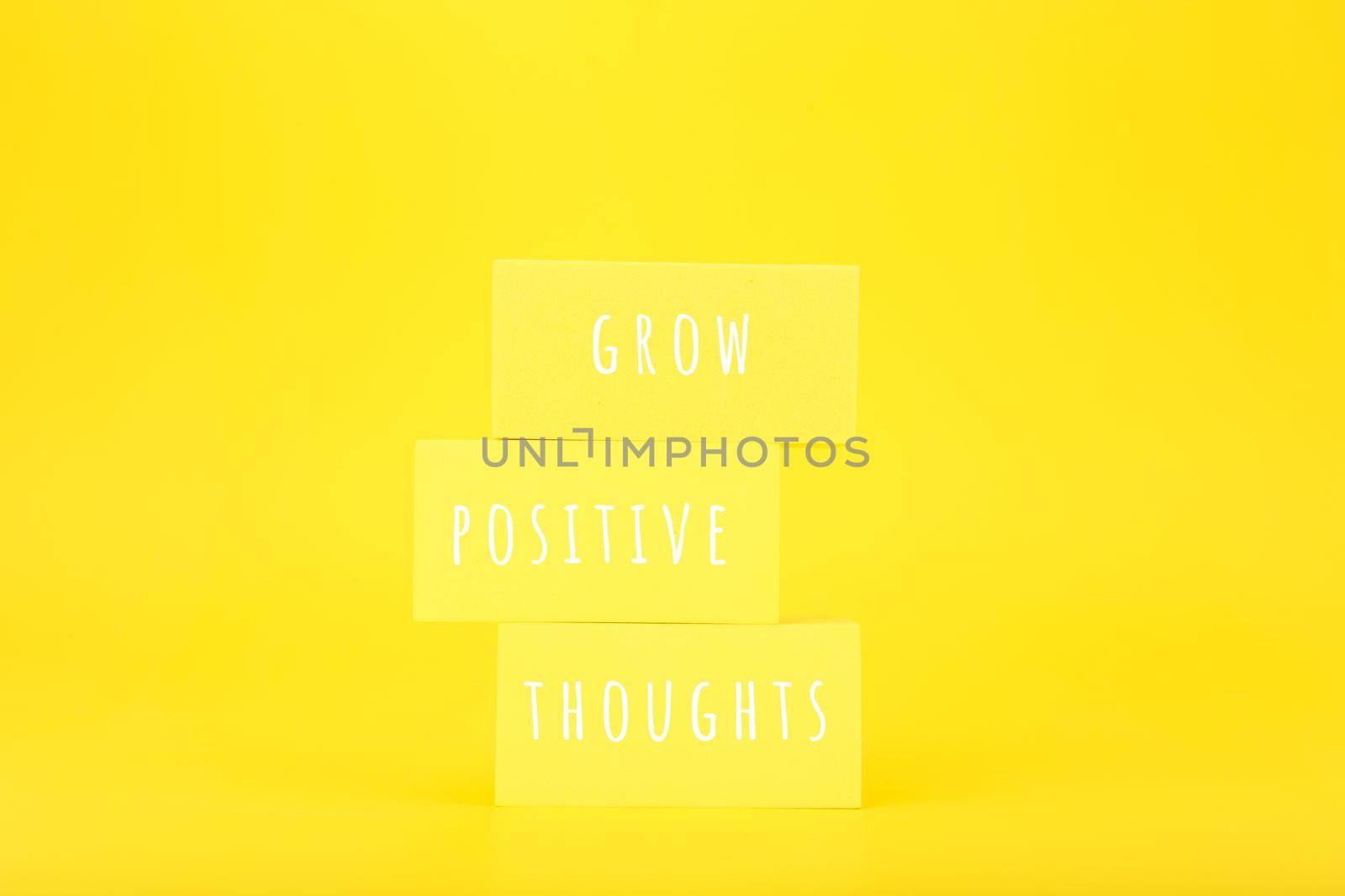 Positive affirmation or motivational quote concept. Grow positive thoughts written on yellow rectangles on yellow background  by Senorina_Irina