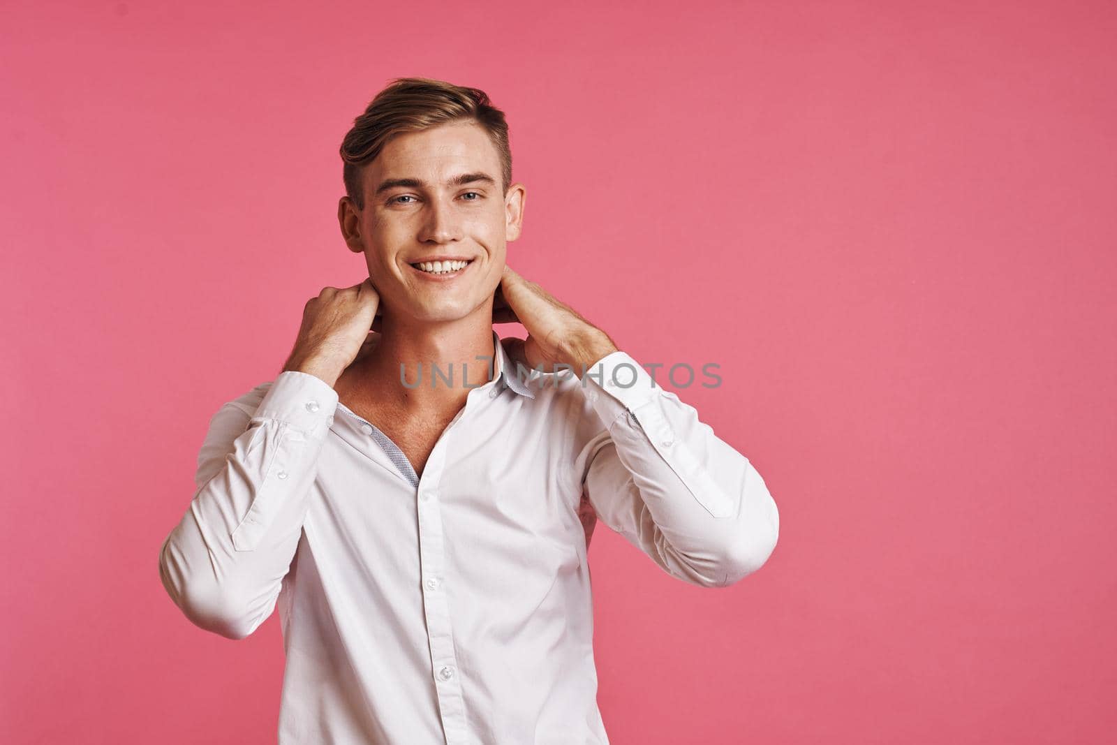 handsome man posing white shirt fashion self confidence pink background. High quality photo