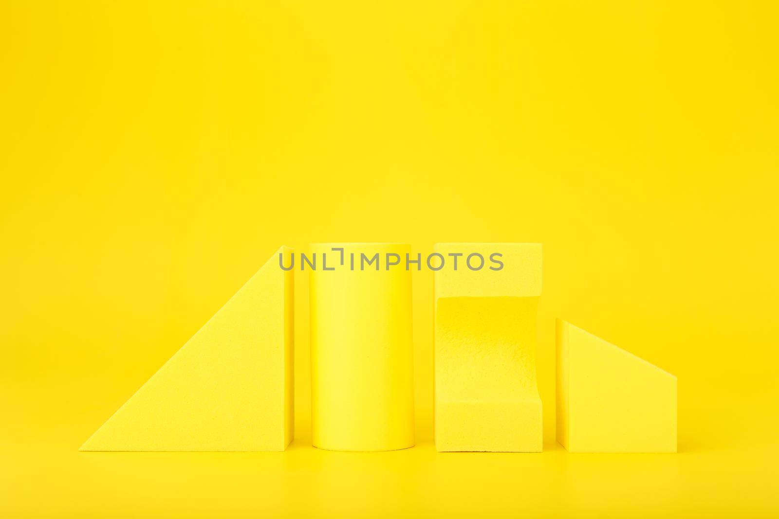 Abstract trendy futuristic background in monochromatic yellow colors with copy space. Bright artsy background with yellow geometric shapes against yellow background with copy space