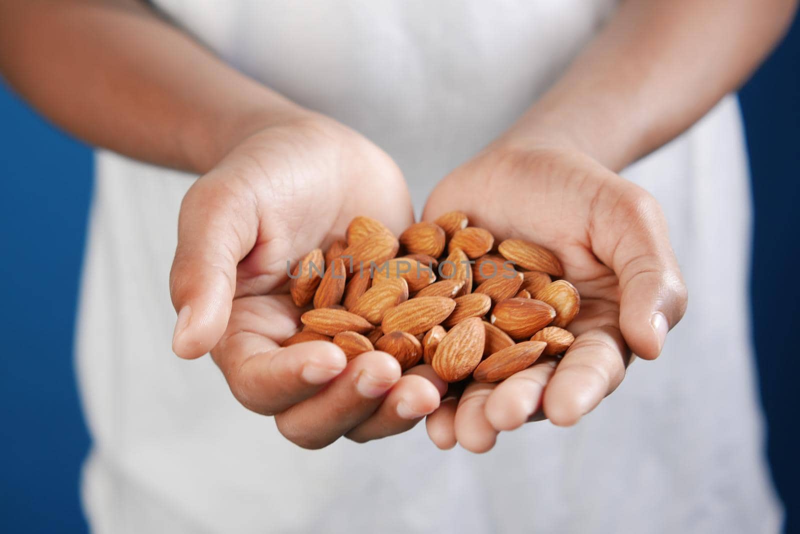 close up of almond nuts on man's hand .