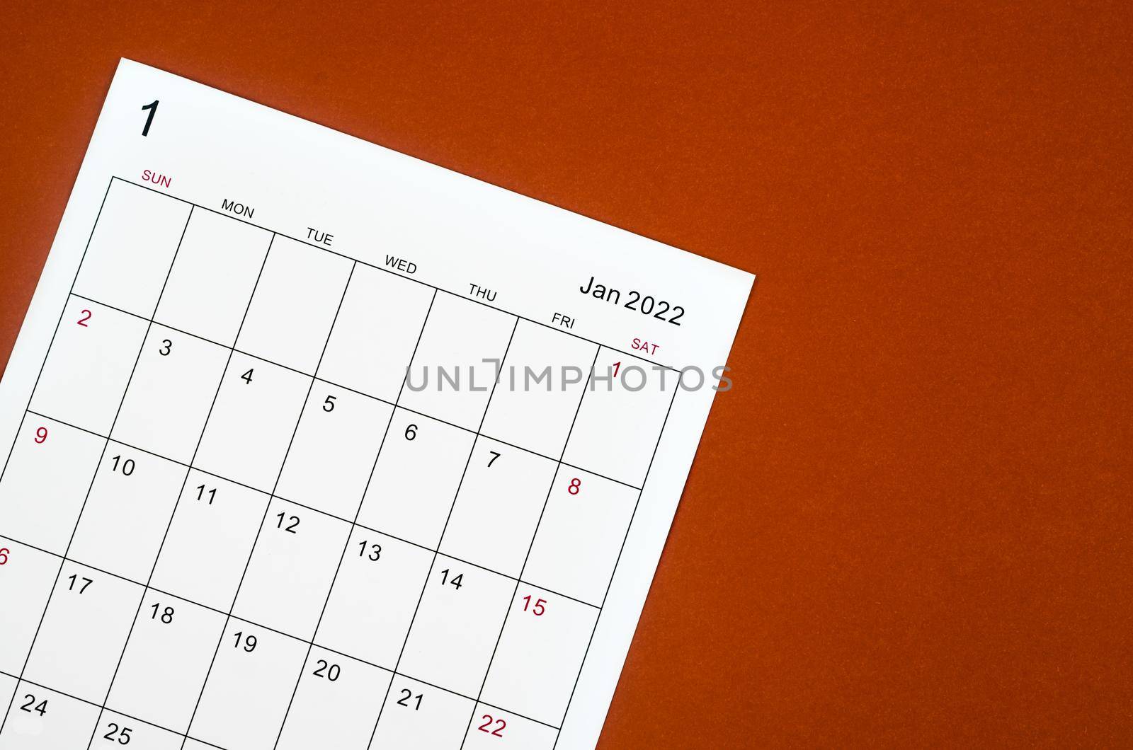 Close up January 2022 calendar sheet on red background.