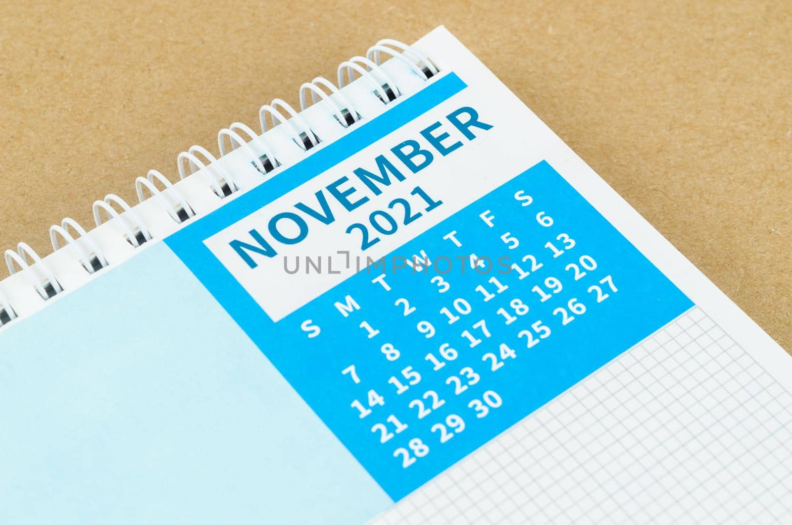 The November 2021 desk calendar on brown background.