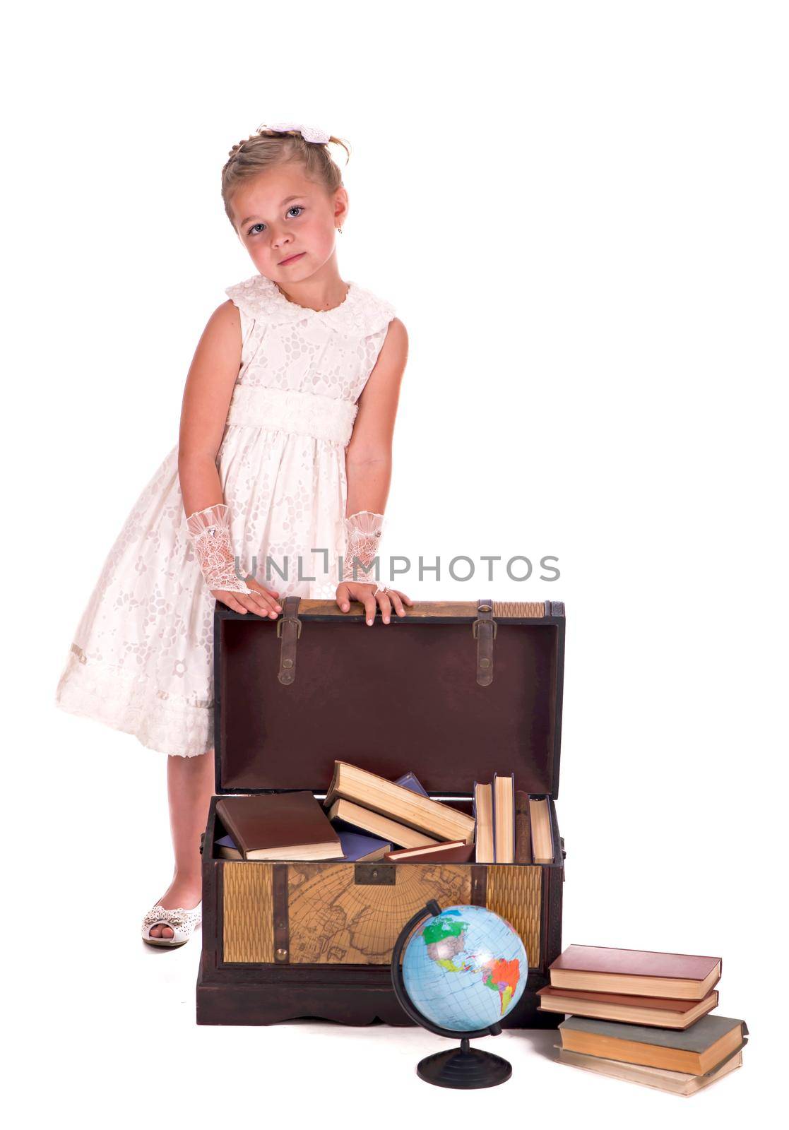 girl and a chest with books. little girl looking inside a trunk with surprise on white background by aprilphoto