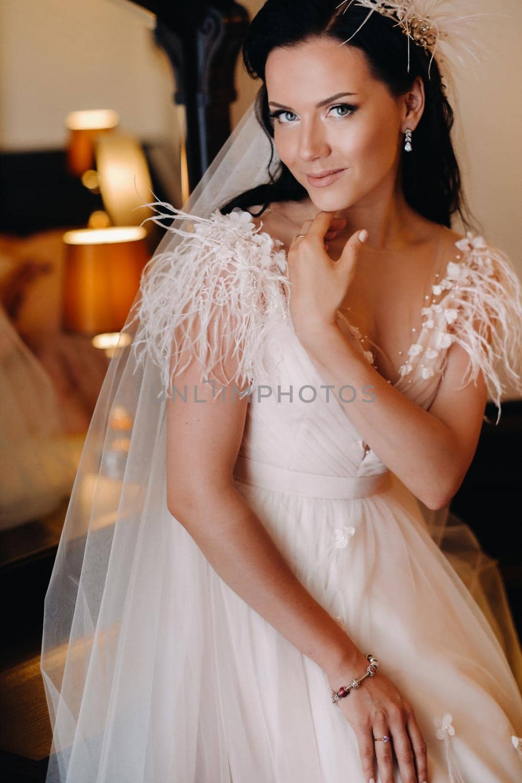 Portrait of the Bride in a wedding dress in the interior of the house near the mirror.