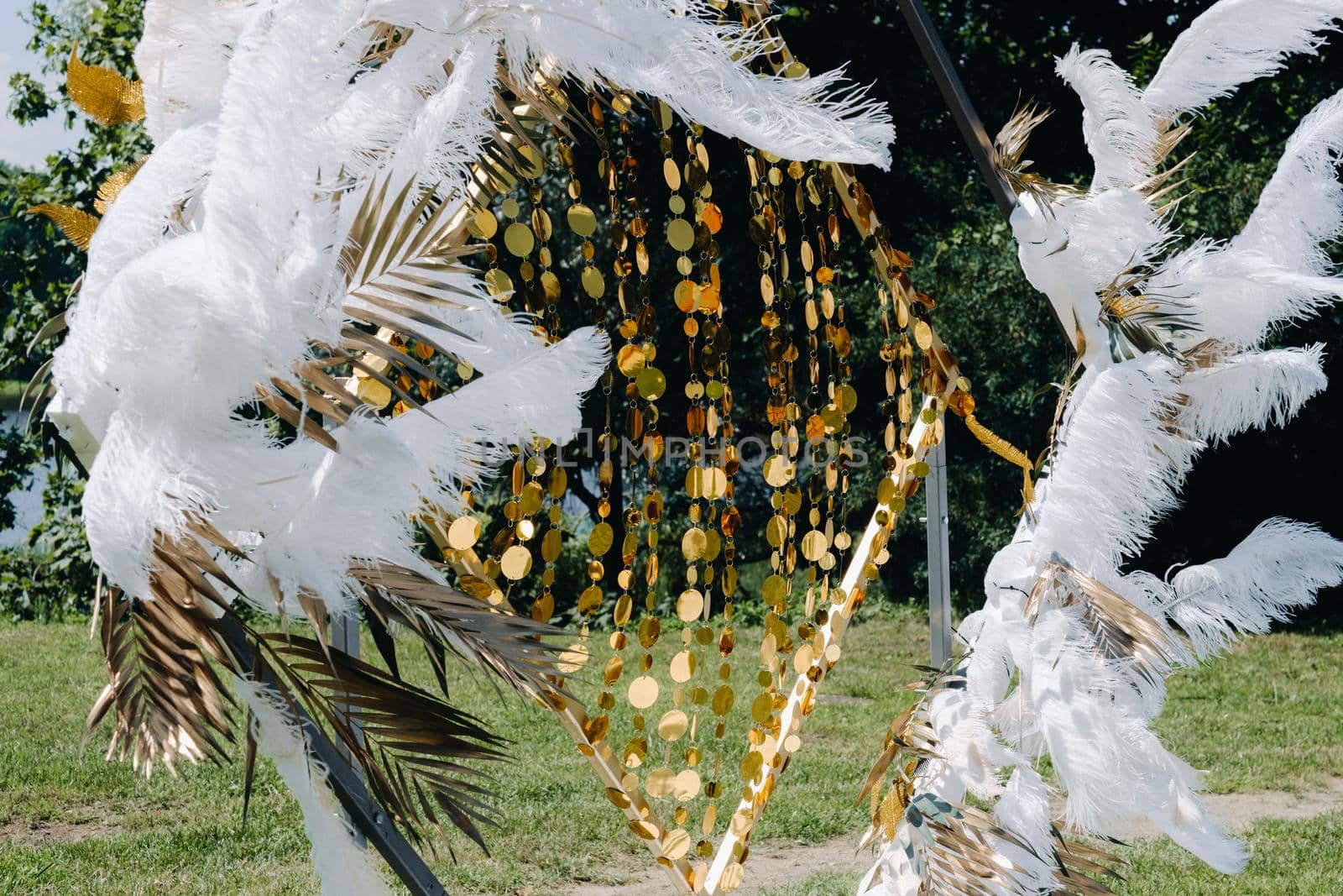 Decorated wedding arch in nature.Wedding ceremony with an arch decorated with feathers in retro style.