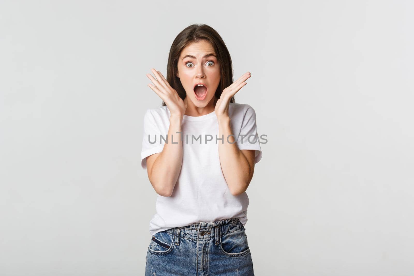 Surprised and amazed brunette girl gasping, drop jaw impressed.