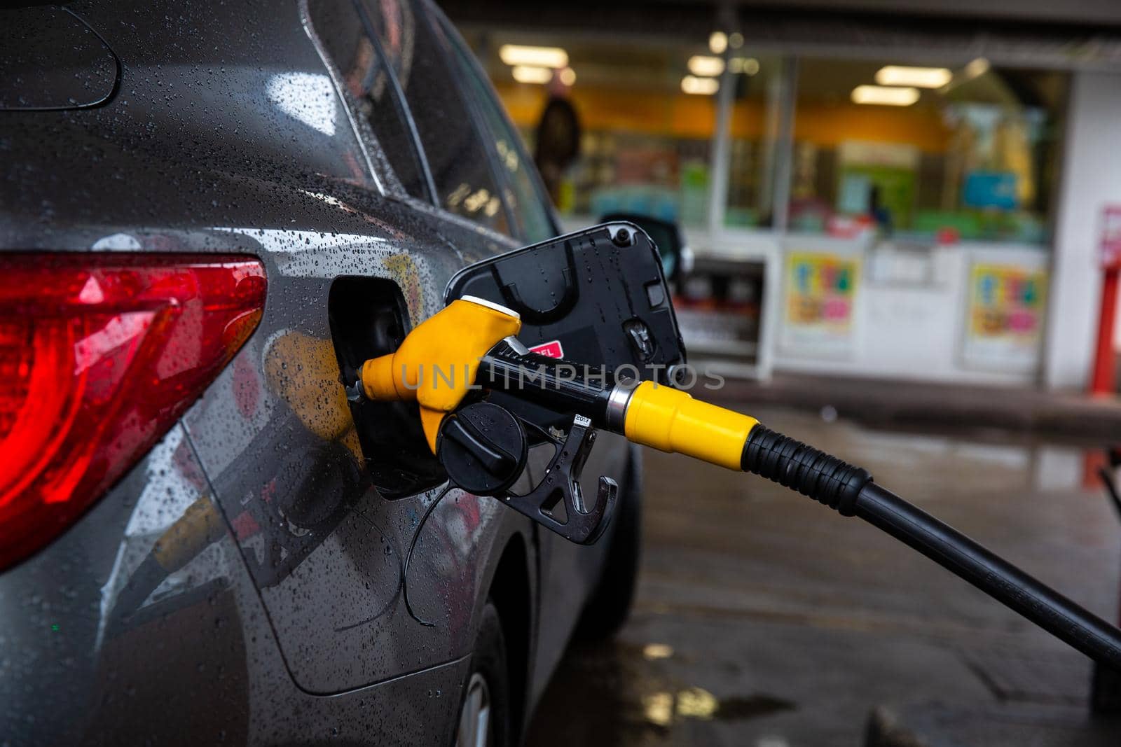 Refueling refilling car vehicle with fuel at refuel fuel gas pump station - Petrol diesel gas pump gun in the tank to fill
