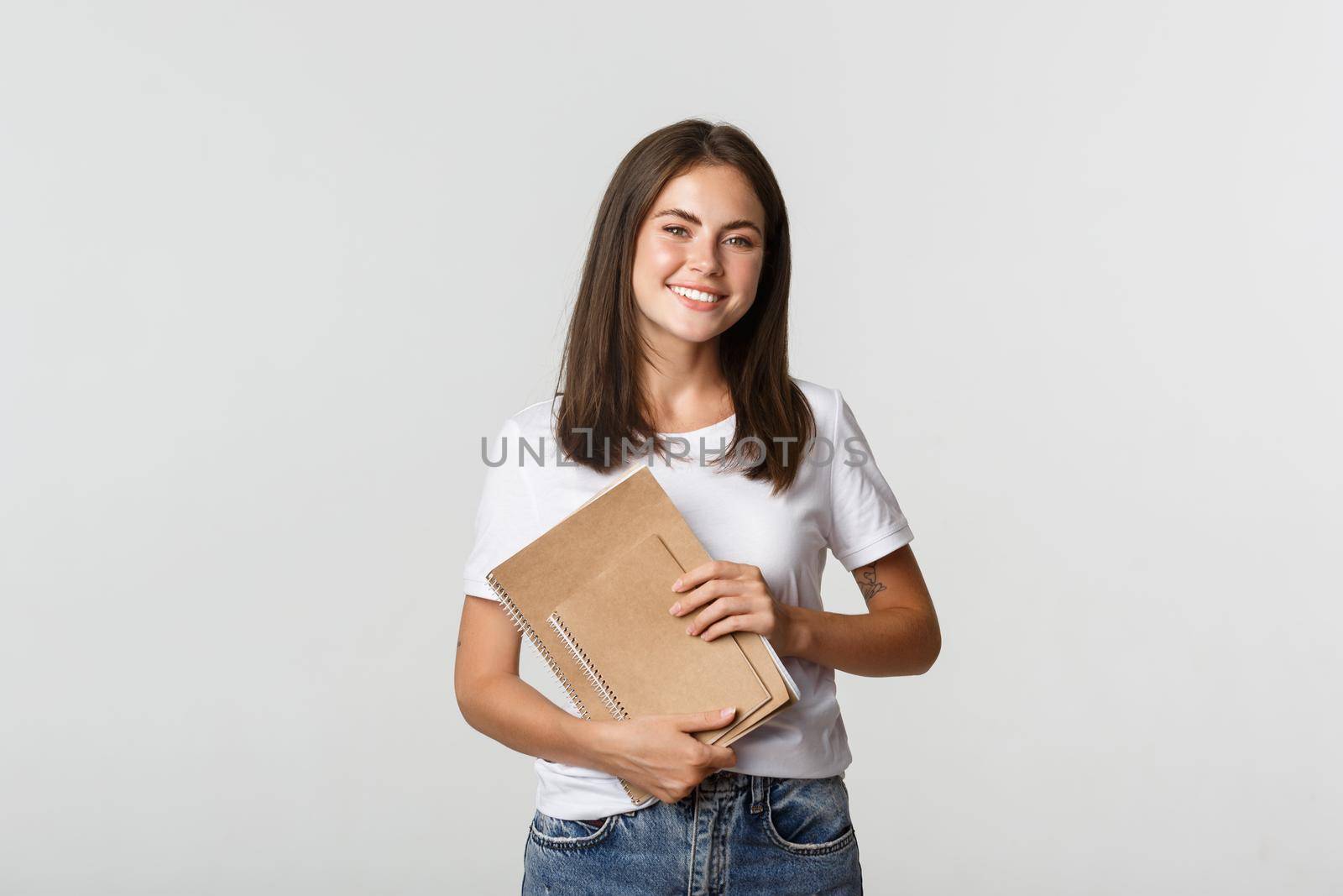 Happy smiling girl student holding notebooks, apply for courses or university.