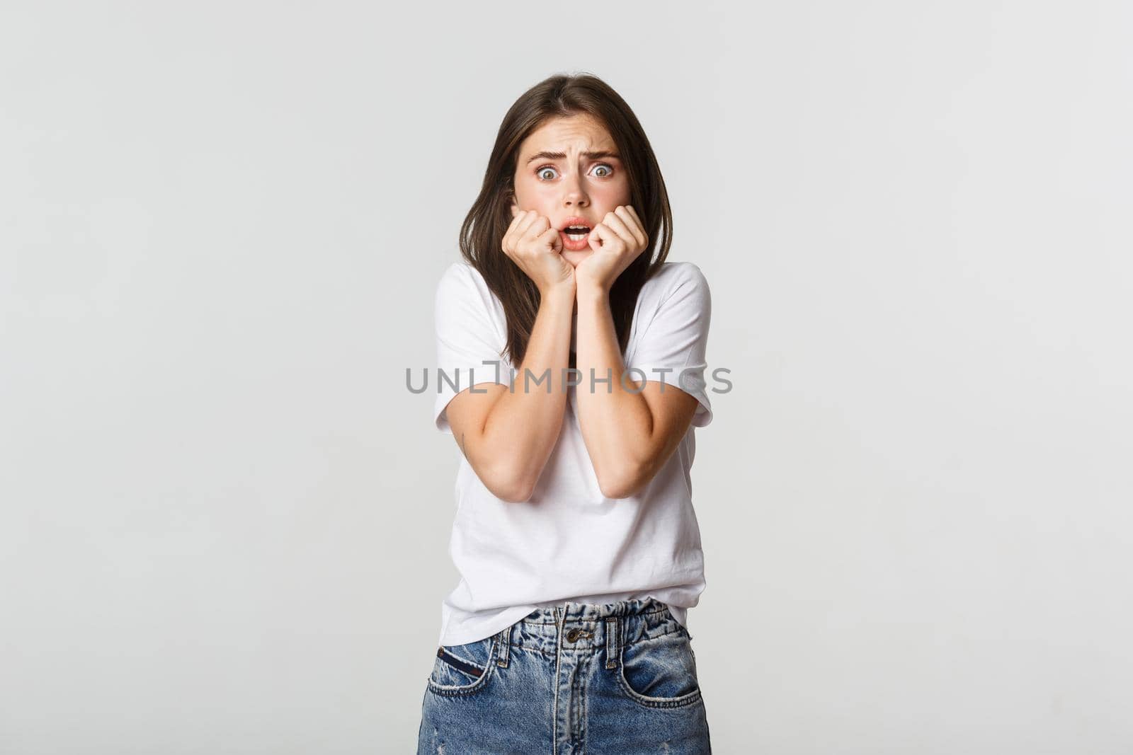 Scared young woman looking terrified, screaming and gasping alarmed.