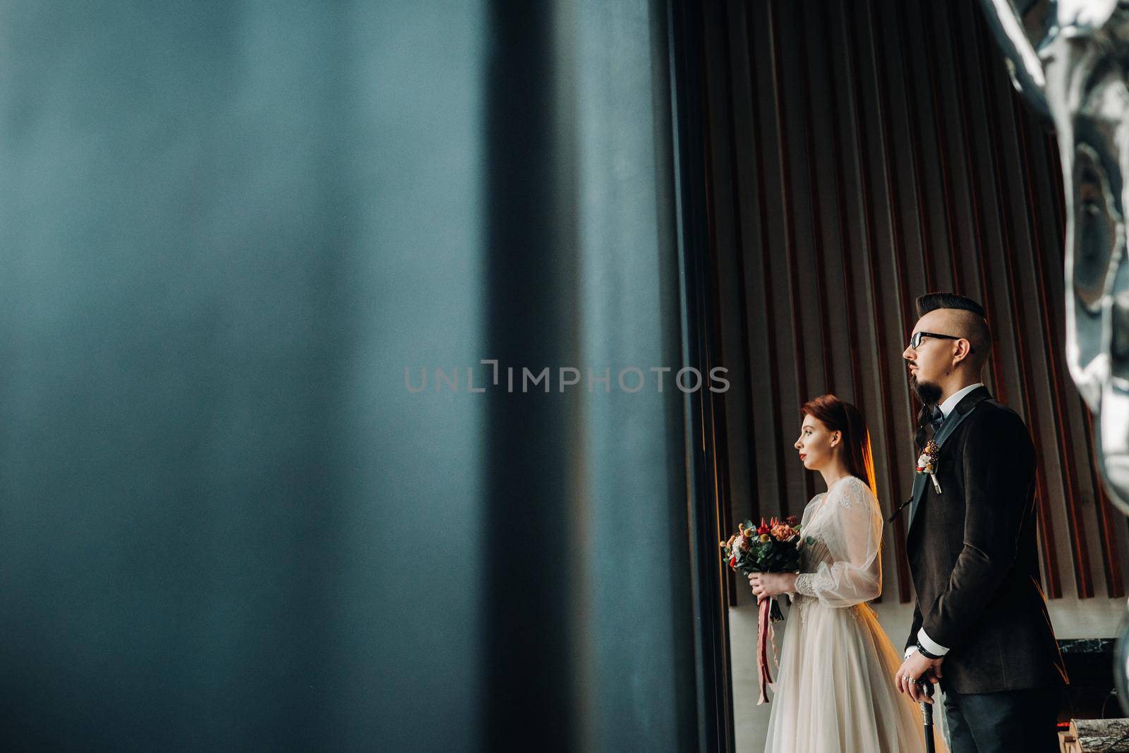 Stylish wedding couple in the interior. Glamorous bride and groom.