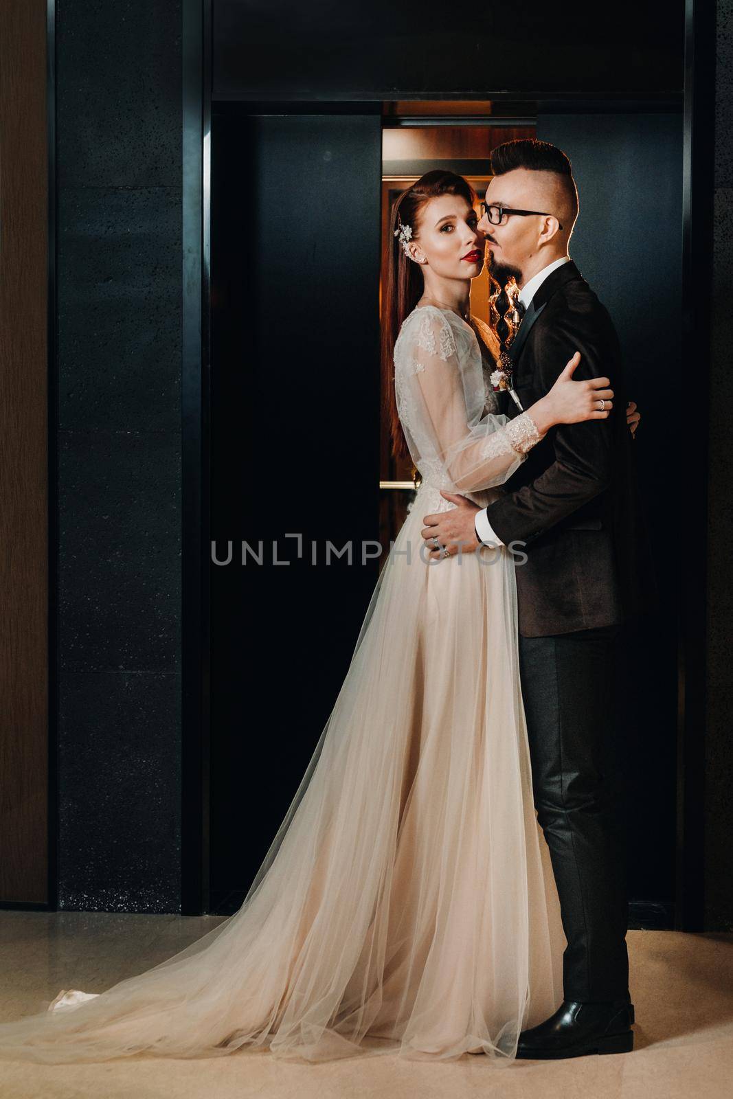 Stylish wedding couple in the interior. Glamorous bride and groom by Lobachad